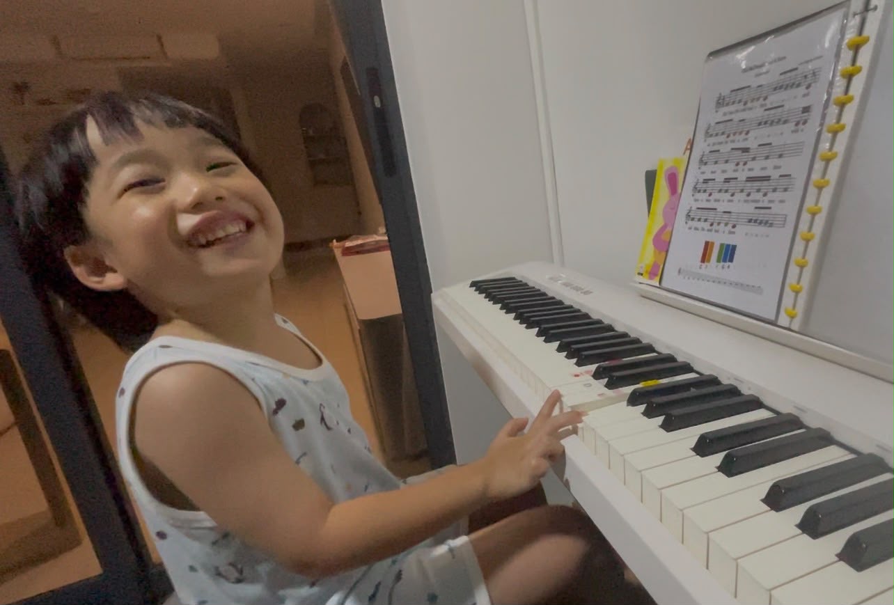 Two young students performing a piano duet at recital